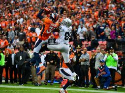 Simmons (I), de los Broncos, intercepta un pase dirigido a Amari Cooper (D), de los Raiders.AFP/ D. Brradford