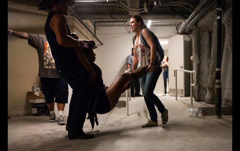 Dos personas asisten a una mujer lesionada tras la agresión. AP/C. Stevens