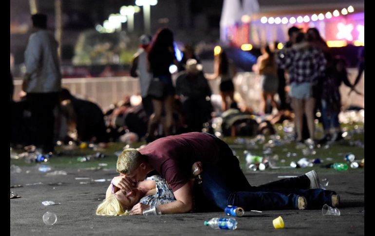 Dos personas permanecen el el suelo para protegerse de los disparos. AFP/D. Becker