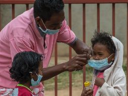 Un adulto protege  con mascarillas a dos menores en Antananarivo. El gobierno ha suspendido clases y comenzado la desinfección de las escuelas. AP/A. Joe