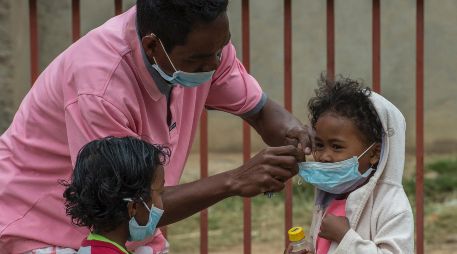 Un adulto protege  con mascarillas a dos menores en Antananarivo. El gobierno ha suspendido clases y comenzado la desinfección de las escuelas. AP/A. Joe