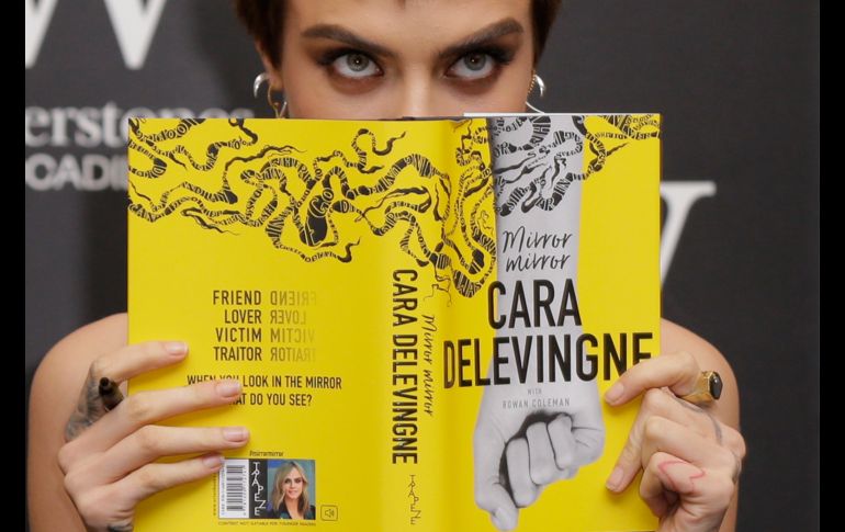 La modelo y actriz Cara Delevingne posa para fotógrafos antes de firmar copias de su novela debut 