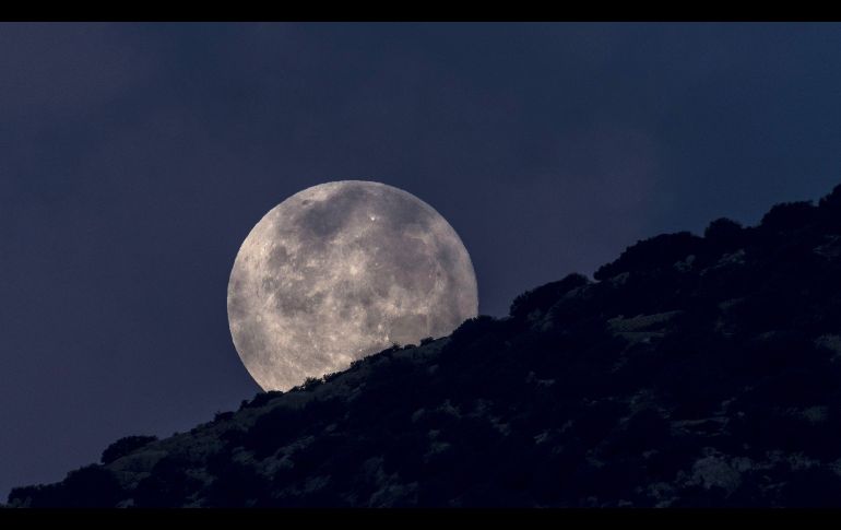 La luna llena asoma tras la isla Dragonera en Sant Elm, España. EFE/C. Cladera