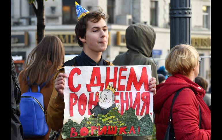 Un opositor sostiene un cartel que dice “ladrón, feliz cumpleaños”. AFP/M. Antonov