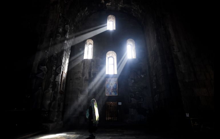 Una mujer ora en el templo de San Pablo y San Pedro, en el monasterio del siglo IX en Tatev, Armenia.  AFP/K. Kudryavtsev