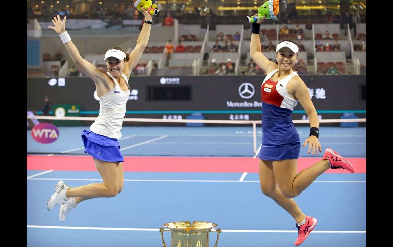 La suiza Martina Hingis y la taiwanesa Chan Yung-Jan posan con el trofeo del campeonato en dobles femenil del Abierto de China, que se disputó en Pekín. AP/M. Schiefelbein