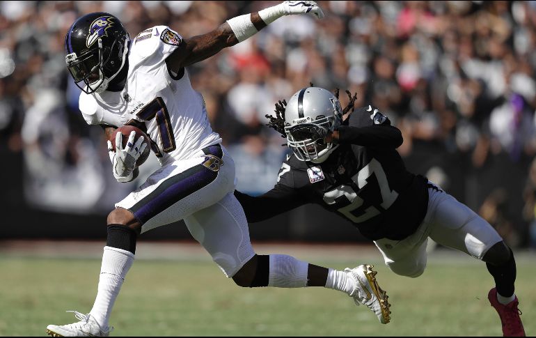 Wallace (I) acarrea un pase de Flacco ante el acoso de Nelson (D), de los Raiders. AP/M. Sánchez