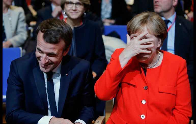 La canciller alemana Angela Merkel y el presidente francés Emmanuel Macron bromean durante la inauguración de la Feria del Libro de Fráncfort, que este año tiene como nación invitada a Francia.   AP/M. Probst