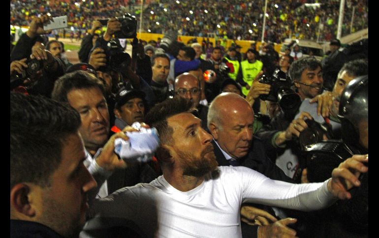 Messi, rodeado de una multitud, arroja su camiseta hacia un numeroso grupo de fanáticos. AFP/J. Cazar