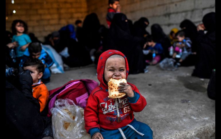 AL RAQA, SIRIA.- Un niño disfruta su alimento en un grupo de desplazados sirios que huyeron de la ciudad de Raqa donde grupos militares sirios y fuerzas especiales de Estados Unidos luchan por combatir a los últimos grupos yihadistas. AFP / B. Kilic