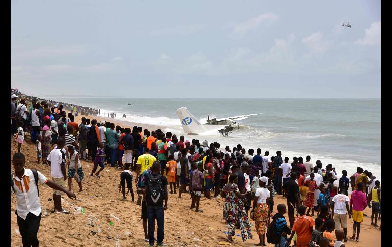 Un grupo de mirones permanece en la playa de Port-Bouet en la ciudad de Abiyán, Costa de Marfil, donde se estrelló un avión utilizado por el ejército francés como parte de una operación antiyihadista. Murieron cuatro personas y otras seis quedaron heridas. AFP / I. Sanogo
