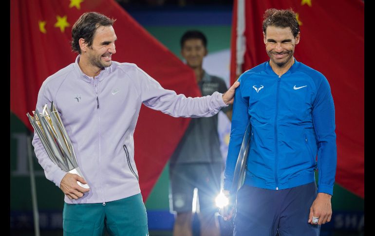 El suizo Roger Federer (i), ganador del torneo de tenis Masters de Shanghái, y el español Rafael Nadal, segundo lugar, reaccionan durante la premiación en la ciudad china. AFP/N. Asfouri