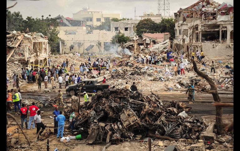 Rescatistas y habitantes se ven en el sitio del atentado de ayer en Mogadiscio, Somalia. La cifra de muertos por el ataque con bomba se elevó a 215 y más de 350 heridos. AFP/M. Abdiwahab