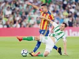 El mexicano Andrés Guardado se barre para tratar de robarle el balón a Rodri, del Valencia, durante el partido de ayer en la Liga española. AFP
