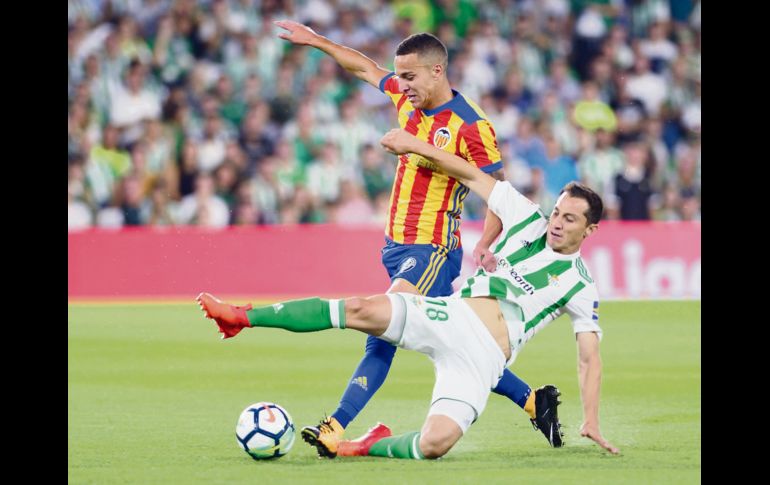 El mexicano Andrés Guardado se barre para tratar de robarle el balón a Rodri, del Valencia, durante el partido de ayer en la Liga española. AFP