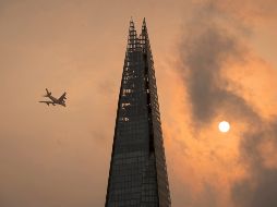 A plane flies past the Shard in central London - A plane flies past the Shard in central London, as the sky takes on an unusual orange colour caused by Hurricane Ophelia Monday Oct. 16, 2017. The unusual occurrence was due to the remnants of the hurricane dragging in tropical air and dust from the Sahara.  (Dominic Lipinski/PA via AP) APTOPIX Britain Weather - UNITED KINGDOM OUT  NO SALES  NO ARCHIVE  PHOTOGRAPH CANNOT BE STORED OR USED FOR MORE THAN 14 DAYS AFTER THE DAY OF TRANSMISSION