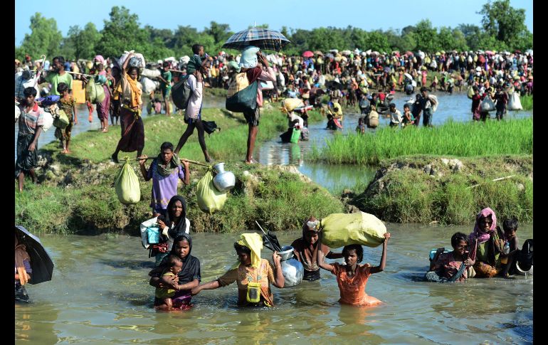Refugiados rohinyás caminan por un canal en Ukhia, Bangladesh, tras cruzar el río Naf en su huida de la violencia en Birmania.