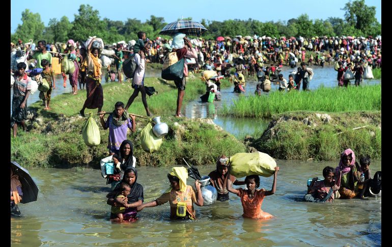 Refugiados rohinyás caminan por un canal en Ukhia, Bangladesh, tras cruzar el río Naf en su huida de la violencia en Birmania.