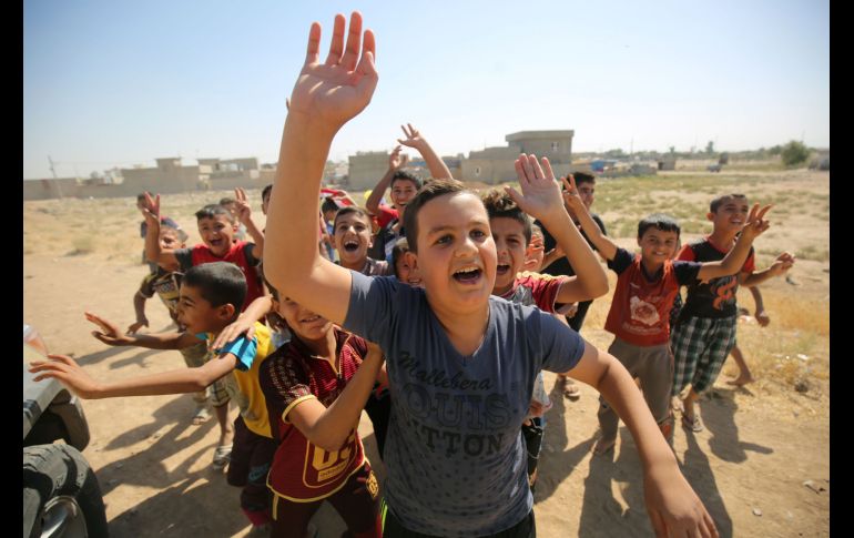 Niños saludan a fuerzas iraquíes que llegan al primer vecindario en las afueras de Kirkuk, durante el operativo contra los combatientes kurdos. AFP/A. Al Rubaye