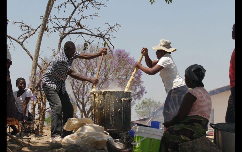 Padres preparan el almuerzo para sus hijos en el colegio Munyawiri, en Zimbabu, en el marco del Día Internacional de la Alimentación. EFE/ A. Ufumeli