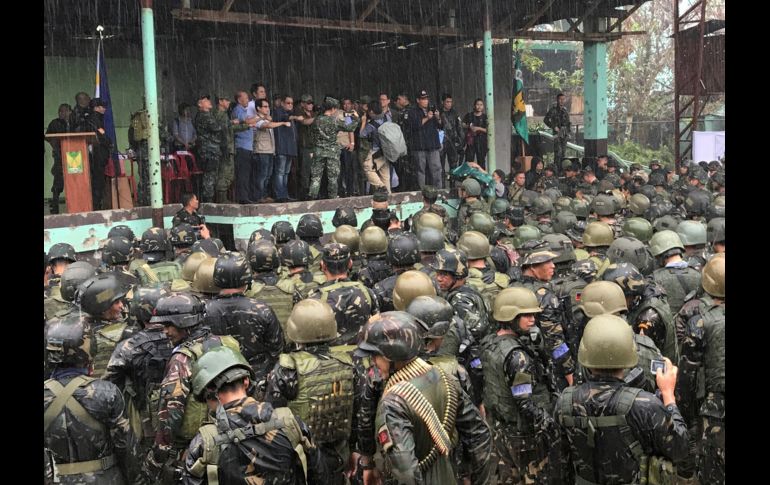 Ataviado con gorra militar y gafas de sol, Duterte (c) recibió la ovación de las tropas tras declarar la liberación de Marawi. AP/B. Marquez