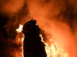 Un bombero mira las llamas del incendio que trata de controlar. AFP/F. Leong