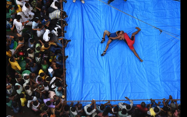 Luchadores amateurs participan en una competencia en un ring colocado en una calle transitada en Calcuta, organizada en el marco del Festival 