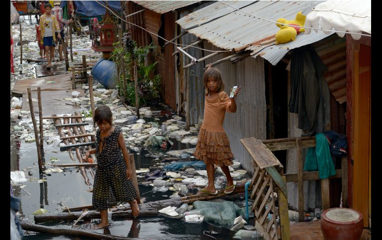 Niñas camboyanas andan entre agua contaminada en Phnom Penh. AFP/T. Chhin Sothy