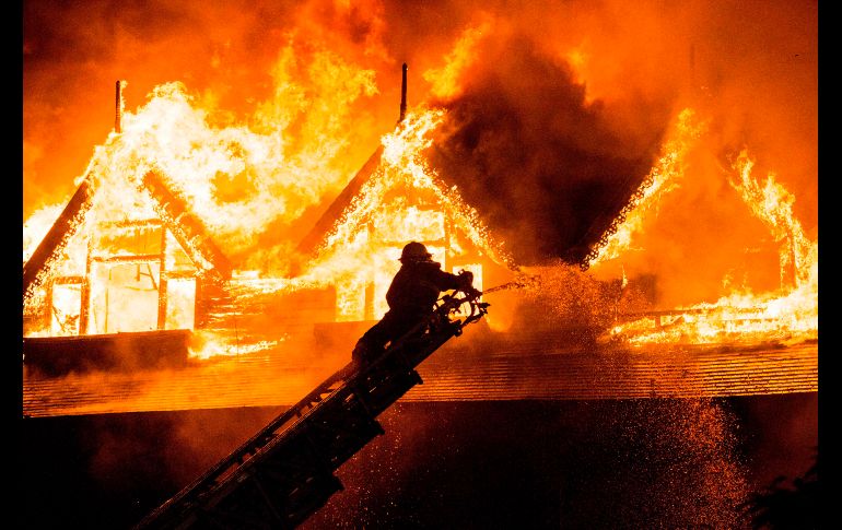 Un bombero combate un incendio en el hotel Kandawgyi Palace en Rangún, Birmania. Una persona murió a causa del fuego desatado esta madrugada. AFP/Y. Aung Thu