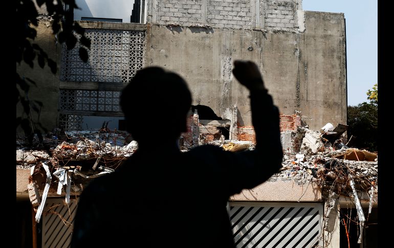 Un hombre frente a un edificio colapsado en las calles Amsterdam y Laredo, en Ciudad de México guarda silencio en un acto en memoria de las víctimas del sismo. AP/M. Ugarte
