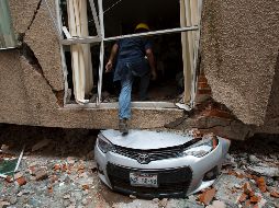 Un hombre frente a un edificio colapsado en las calles Amsterdam y Laredo, en Ciudad de México guarda silencio en un acto en memoria de las víctimas del sismo. AP/M. Ugarte