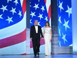 Se trata de un vestido largo de seda color vainilla, sin hombros, con una abertura en la parte frontal baja, y acentuado por una banda de crepe que va desde la cintura hasta el escote, y una cinta de color rojo alrededor de la cintura. AFP / ARCHIVO