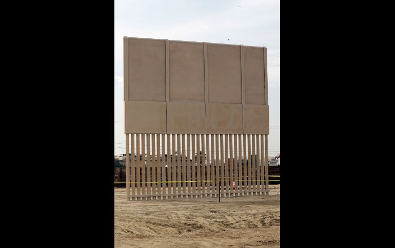 Muro con postes de metal en la parte inferior, una placa metálica en medio y un bloque de concreto en lo alto. AP/G. Bull
