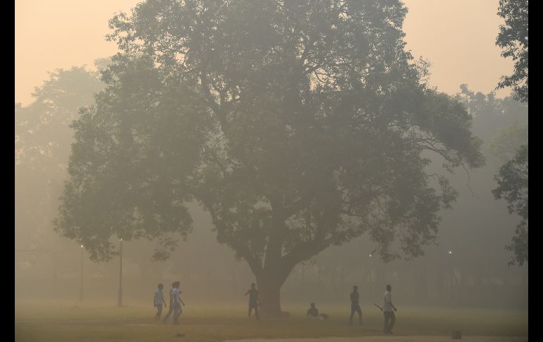 Hombres juegan críquet entre una densa capa de esmog en Nueva Delhi, un día después del Festival 