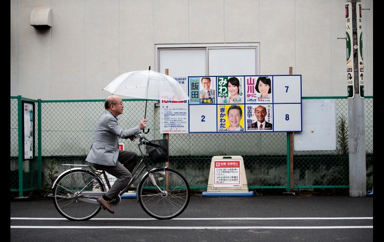 Un hombre pasa junto a propaganda de candidatos para la elección general en Koshigaya, Japón. Se prevé que un tifón impacte el país el 22 de octubre, día de los comicios. AFP/B. Mehri