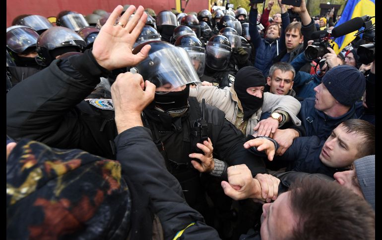 Manifestantes chocan con policías frente al Parlamento ucraniano en Kiev. Simpatizantes de la oposición demandan quitar la inmunidad de legisladores y cambios en la ley electoral. AFP/S. Supinsky