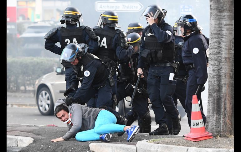 Policías detienen a un hombre durante enfrentamientos con aficionados al futbol, previo a un partido de la Liga francesa entre Marsella y el París Saint Germain en Marsella. La Poicía detuvo a 10 personas. AFP/B. Horvat