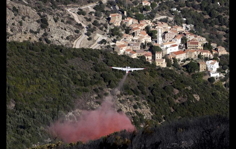 Un avión arroja un retardante de fuego sobre un incendio forestal cerca de Palasca, en Francia. AFP/P. Pochard-Casabianca