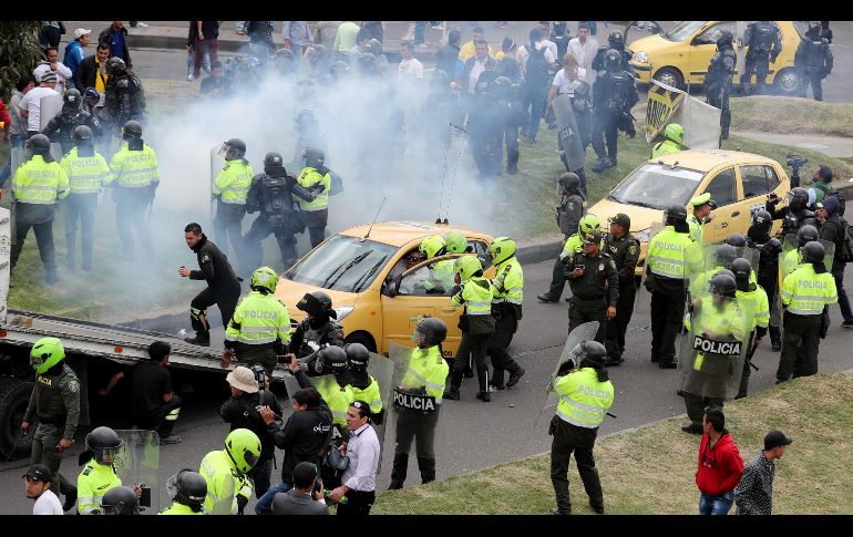 Miembros de la Policía de Colombia inmovilizan taxis durante una protesta en Bogotá. Taxistas comenzaron hoy una huelga para exigir la regulación del servicio de las plataformas Uber y Cabify. EFE/L. Muñoz