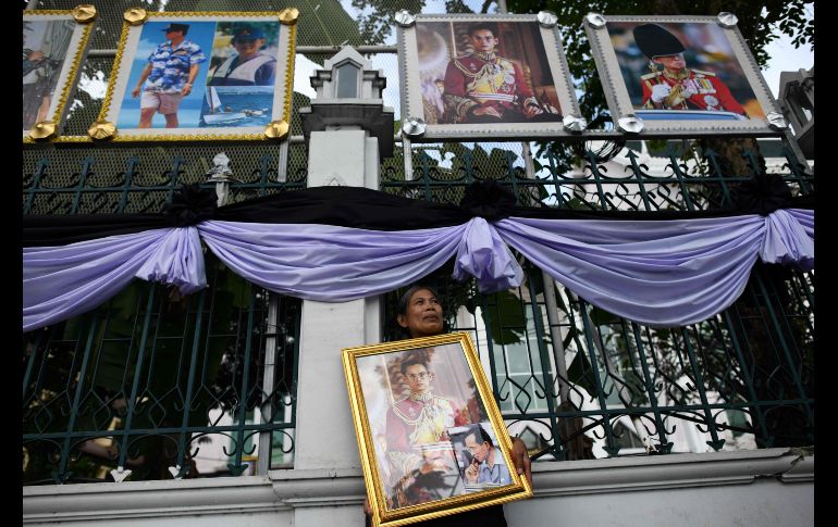 Una mujer sostiene un enorme cuadro del fallecido rey mientras espera a que comiencen las exequias. AFP/A. Wallace