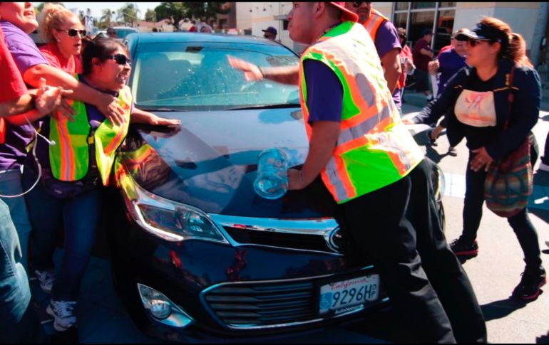 Una mujer golpeó el capó del auto al ser empujada por el vehículo y otro manifestante se subió al auto en movimiento. AP / A. Mendoza