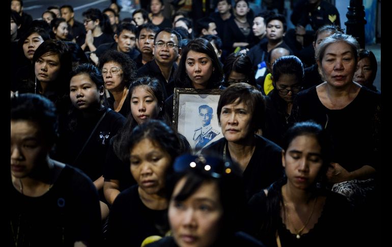Habitantes oran por el fallecido rey Bhumibol Adulyadej en Bangkok.Tailandia puso hoy fin a los cinco días de las exequias del monarca con el reparto de sus cenizas y huesos entre dos templos y el Palacio Real. AFP/Y. Aung Thu