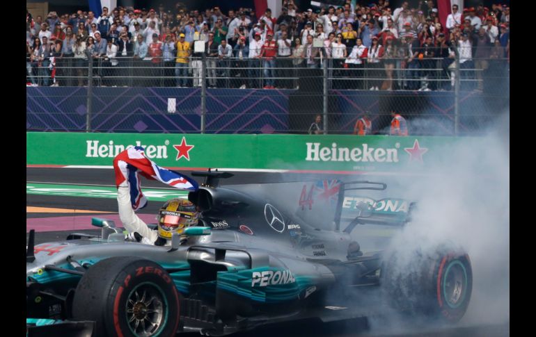 El piloto británico Lewis Hamilton, de la escudería Mercedes, festeja al final del Gran Premio de México, en  Ciudad de México, tras conseguir su cuarto título de la temporada de la Fórmula 1. AP/R. Blackwell