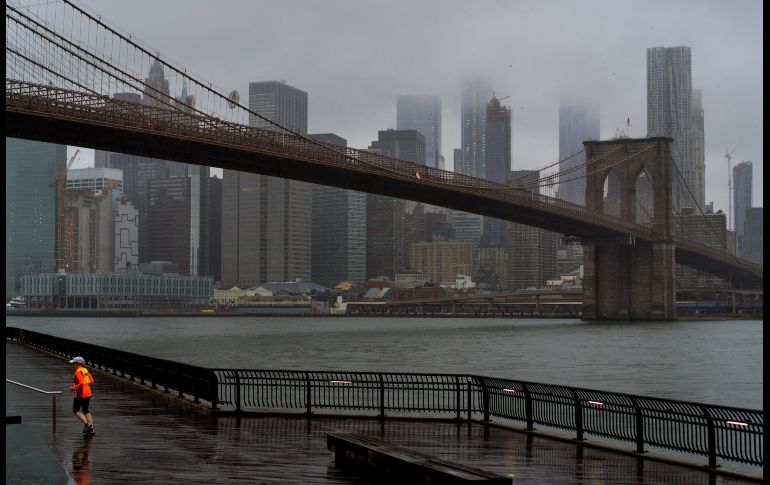 Un corredor se ve mientras nubes cubren el cielo de Manhattan, en Nueva York, en el quinto aniversario del paso de la supertormenta 
