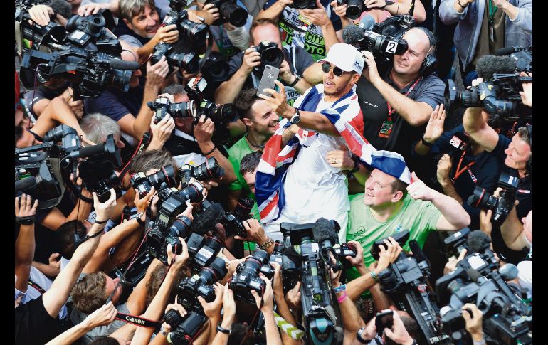 Centro de atracción. El británico Lewis Hamilton celebró su cuarto título mundial rodeado de cámaras tras concluir el Gran Premio de México ayer en el Autódromo Hermanos Rodríguez. AFP