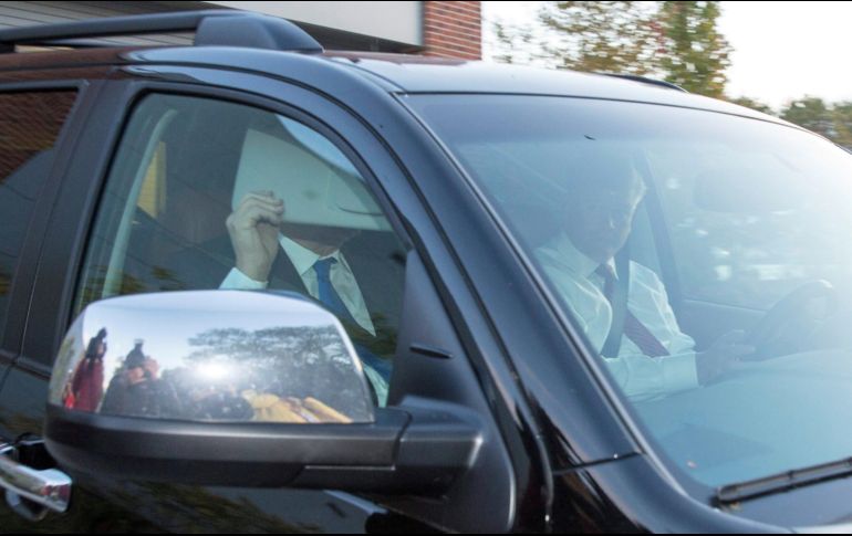 El ex director de campaña del presidente estadounidense Donald Trump, Paul Manafort, cubre su rostro mientras sale de su casa en un vehículo en Alejandría. EFE/T. Katapodos