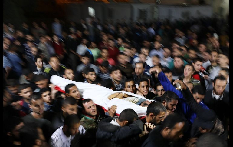 Dolientes llevan el cuerpo de Marwan Al-Agha, de 22 años, que murió junto con otros combatientes palestinos hoy en el bombardeo israelí de un túnel en el sur de la Franja de Gaza. EFE/M. Saber