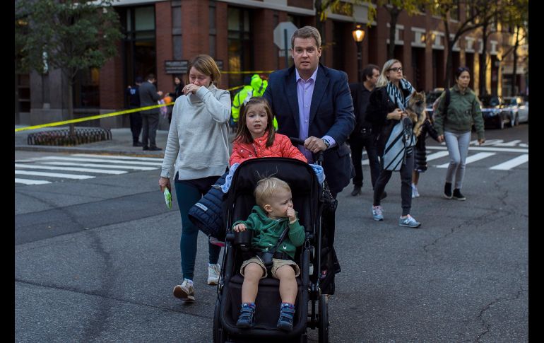 Una mujer llora mientras personas evacuan el área.