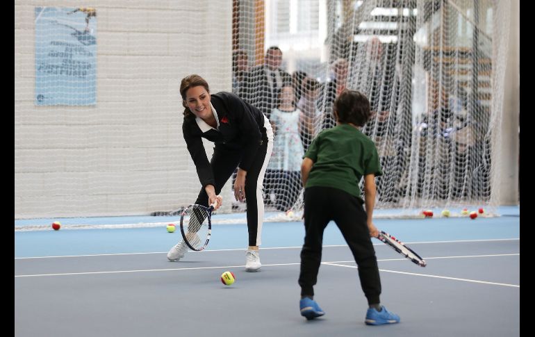Catalina, duquesa de Cambridge (i), juega con niños en una visita a la Asociación de Tenis de Pasto en Londres. AFP/D. Leal-Olivas