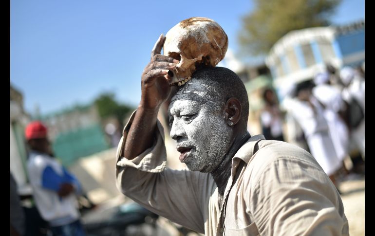 Un hombre con un cráneo participa en una ceremonia de vudú en el cementerio Cite Soleil de Puerto Príncipe, Haití. AFP/H. Retamal